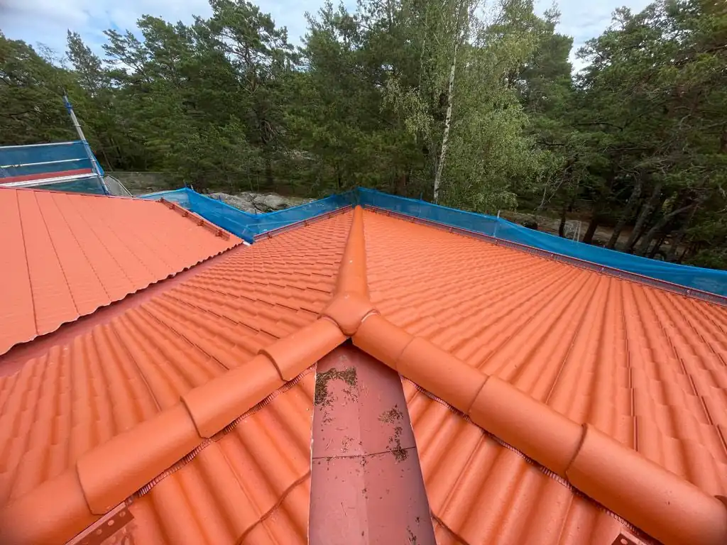 Ränndal där två takfall möts, täckt med nya tvåkupiga betongpannor
