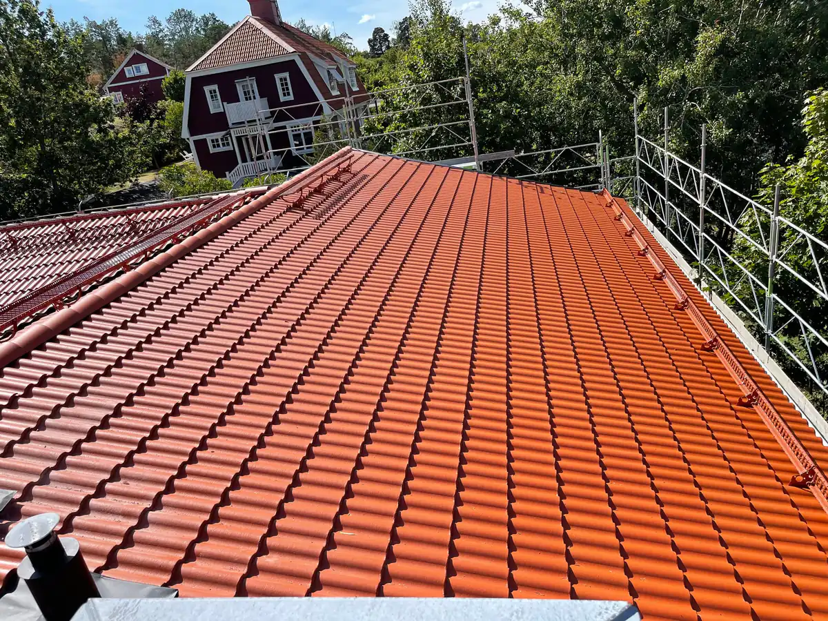 Nylagt rött pannatak på en villa, med ställning och skyddsräcke längs takfoten